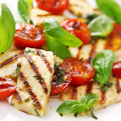 Grilled halloumi cheese with roasted tomatoes and basil