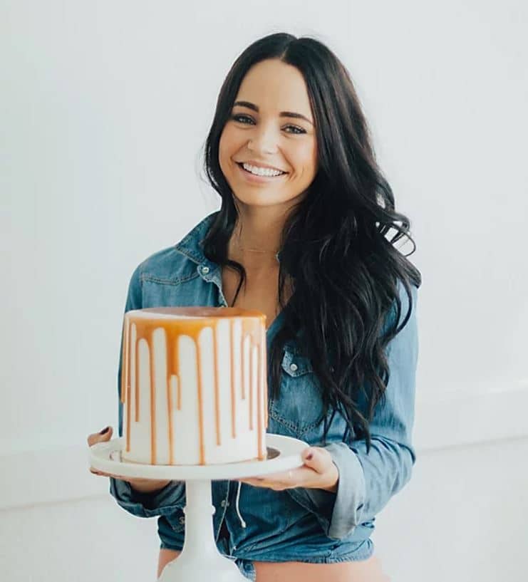 woman holding a Too Sweets Bakery cake