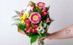 person holding a pink floral arrangement for Mother's Day from Zupan's Markets