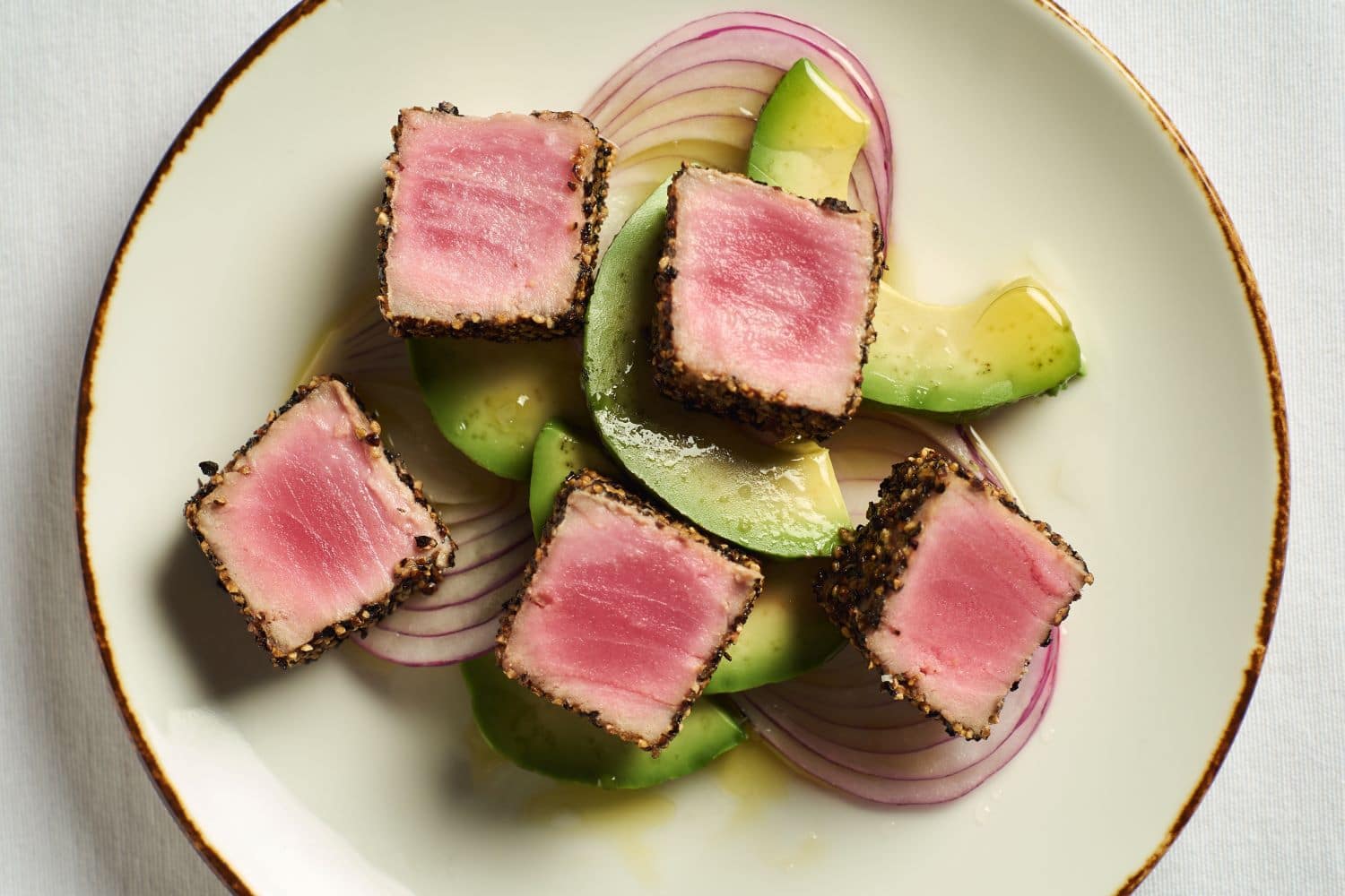 Seared Peppercorn Crusted Ahi Tuna over red onions and avocado