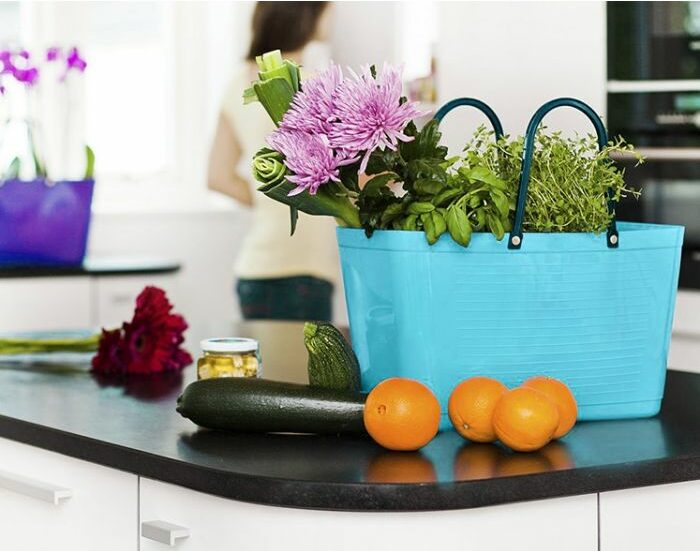 Hinza tote bag on a counter filled with flowers and produce