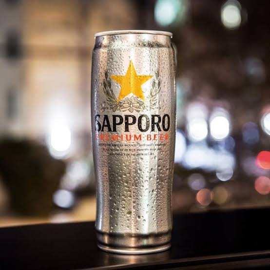Sapporo beer can with a blurry lights background