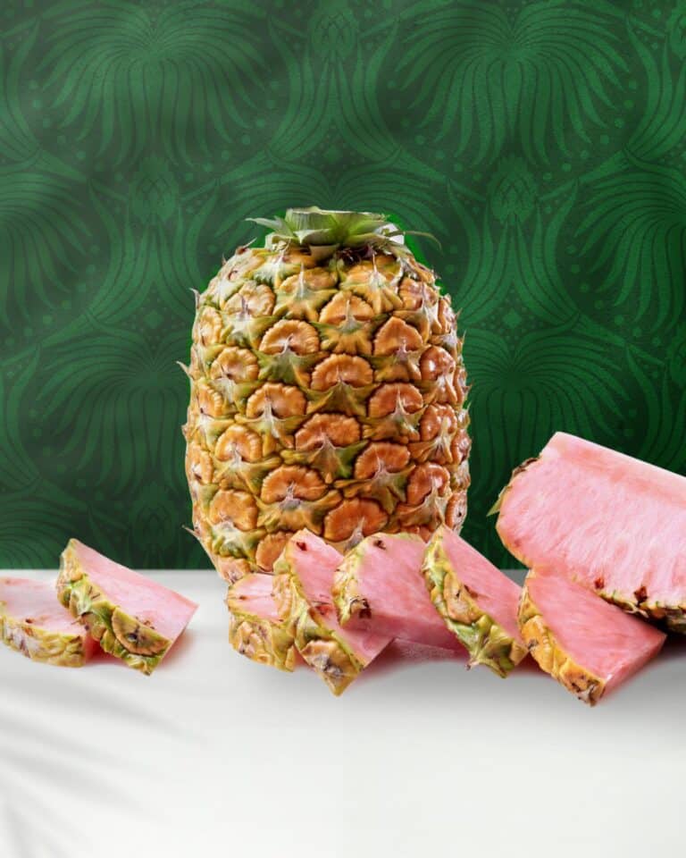 Pink Glow Pineapple on a white table with a green patterned background