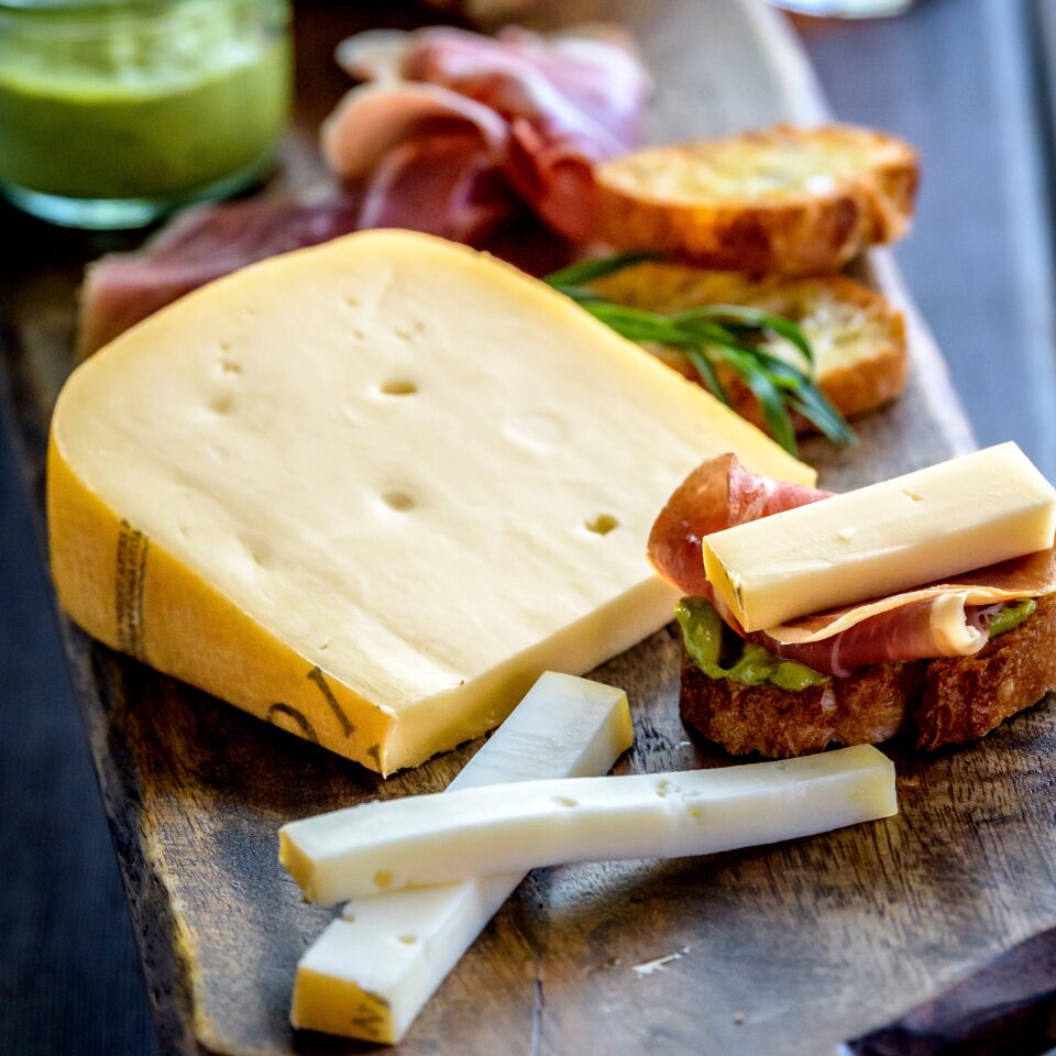 Cheese with bread and meats on a cutting board