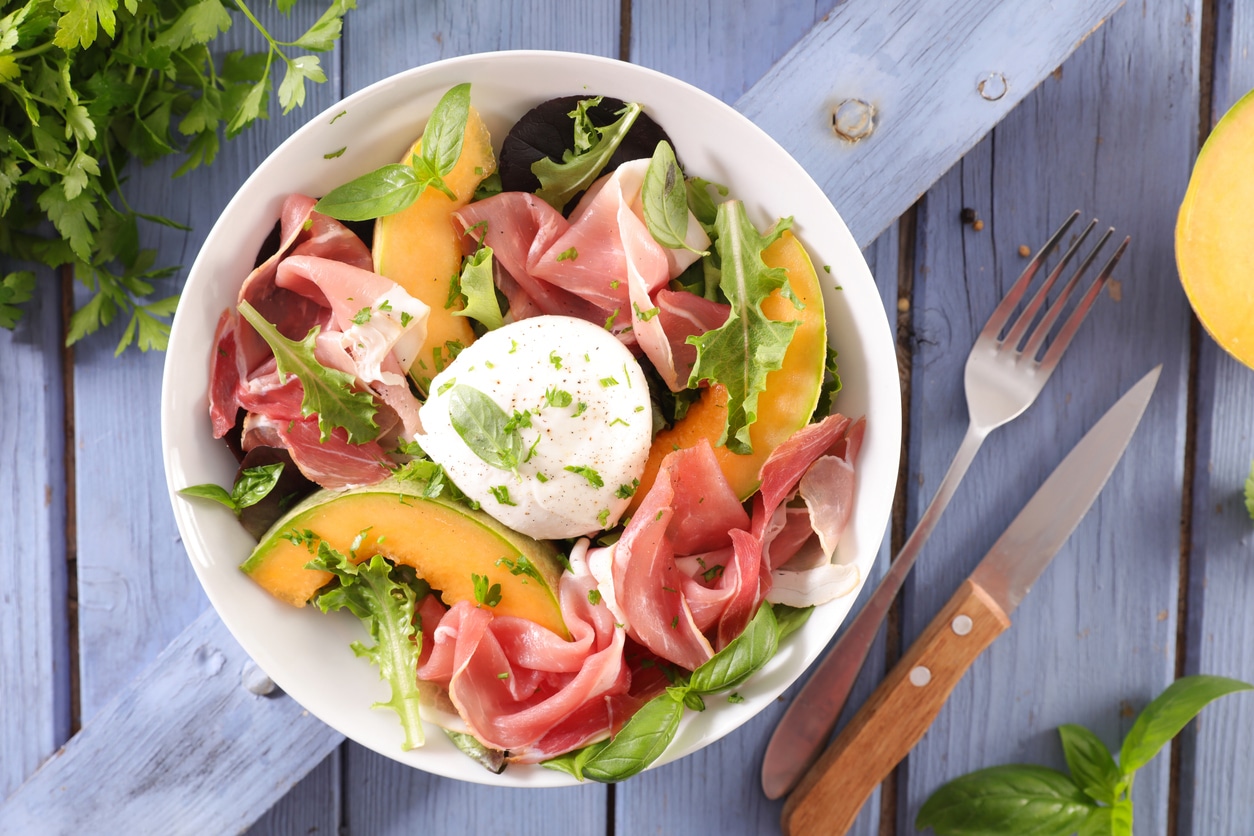 Melon slices with prosciutto ham and lettuce