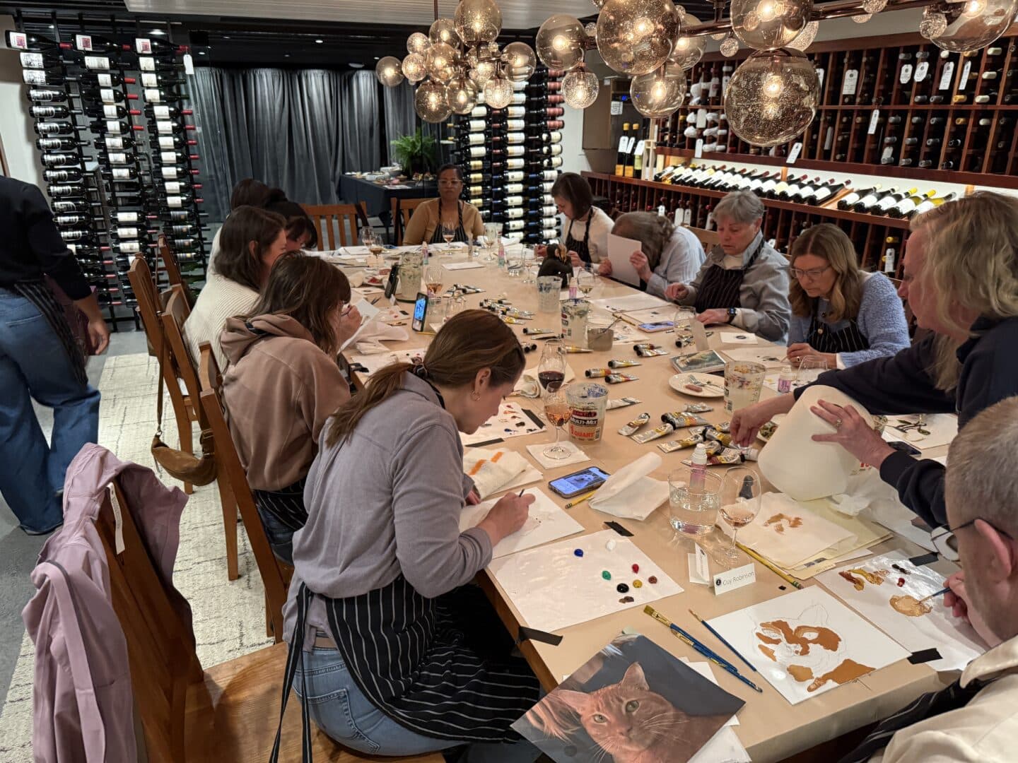 Zupan's paint and sip night - several people painting at a table in a wine cellar
