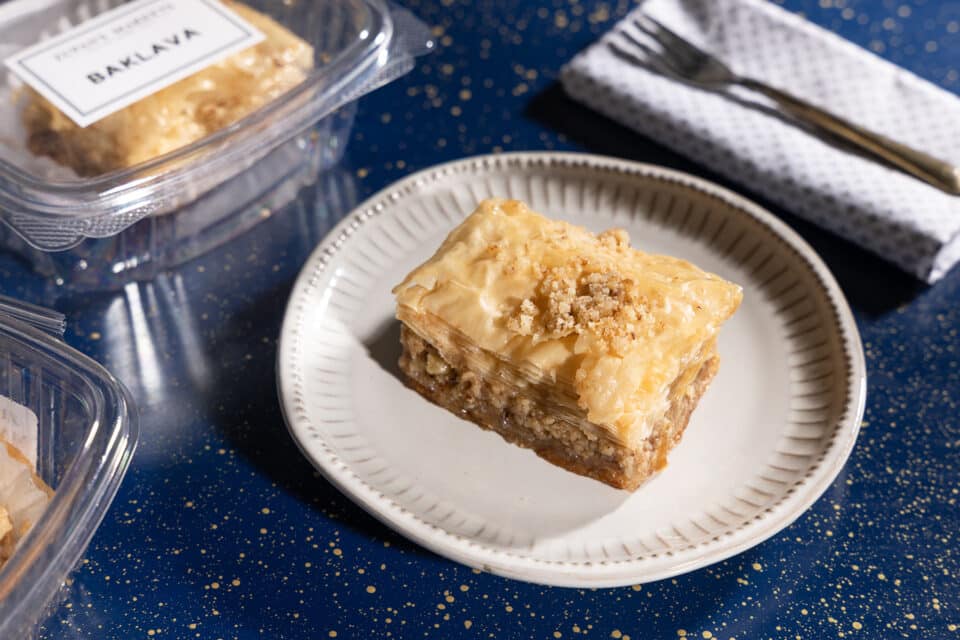Baklava on a white plate on a blue table