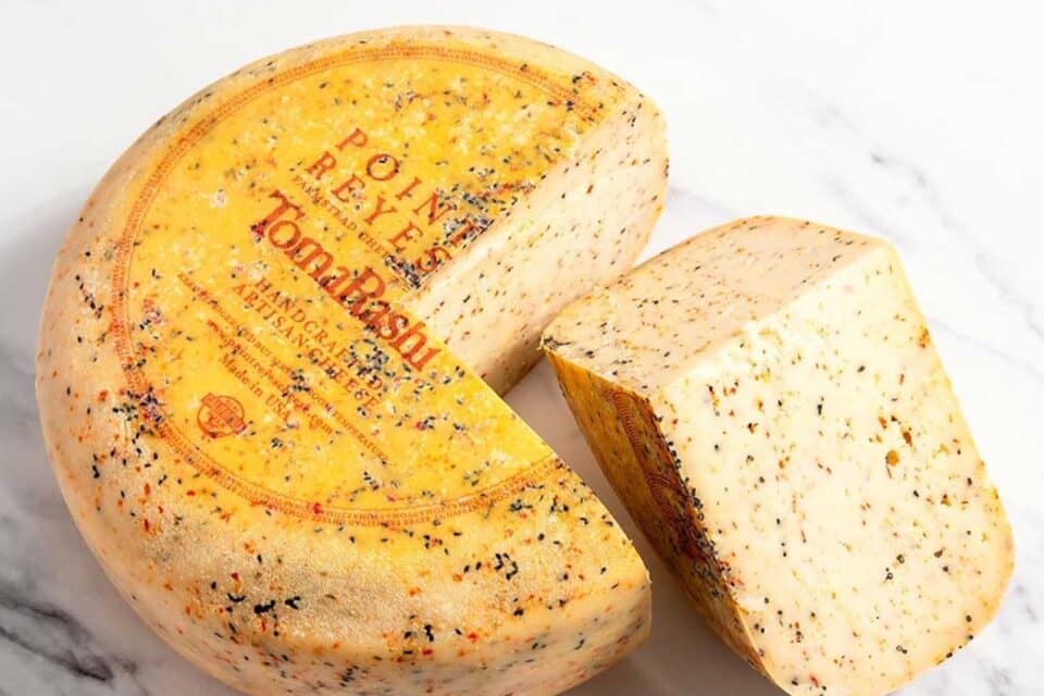 tomarashi point reyes cheese wheel on a marbled surface